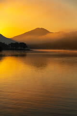 Naklejka premium 湖に映り込むオレンジ色の朝焼け