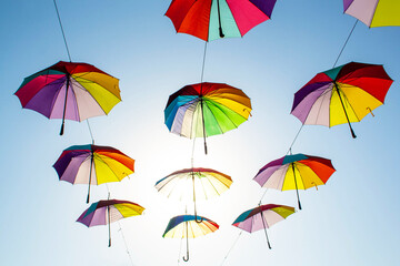 Fototapeta na wymiar Multi-colored umbrellas on the blue sky background. Autumn concept