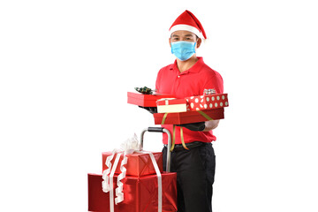 Happy Asian delivery man in red uniform, medical face mask, protective gloves, Christmas hat carry boxes of presents in the hands-on white background during COVID-19 outbreak and Christmas festivities
