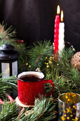 New year's tea party with spices. Red mug with tea surrounded by garlands, fir branches and spices	
