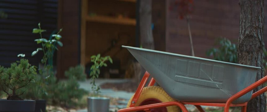 RL DOLLY View of a wheelbarrow standing in a backyard, shed in the background. Shot on RED cinema camera