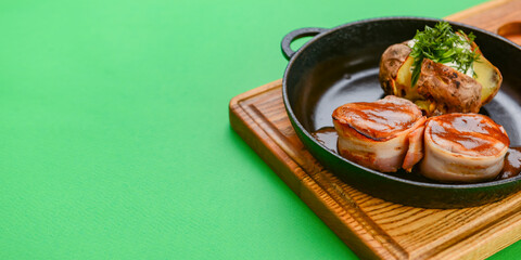 Grilled fillet mignon at the restaurant. Medallion steak dish with baked stuffed potato served in a frying pan.