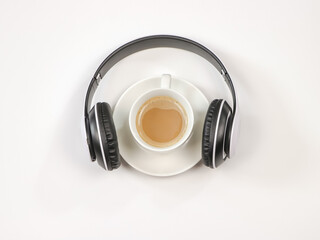 Flat lay of coffee cup cover with headphones on white background. Music and coffee relaxing time concept.