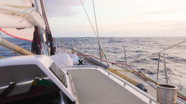 Offshore deep water sailing in Antarctica with sunset light above the Antarctic ocean swells, sailboat cruising in the Drake passage with quiet weather. Adventure travel lifestyle