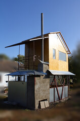 Closed gazebo with a stove and a house with a balcony on the second floor.
