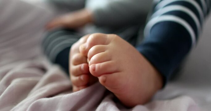 Toddler boy touchign toes. one year old Infant child baby feet