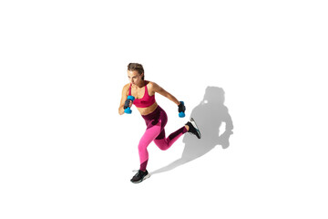 Fototapeta na wymiar Running. Beautiful young female athlete practicing on white studio background, portrait with shadows. Sportive fit model in motion and action. Body building, healthy lifestyle, style concept.