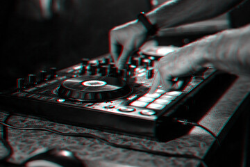 Naklejka premium hands DJ playing electronic contemporary music on the mixer console at a concert in a nightclub