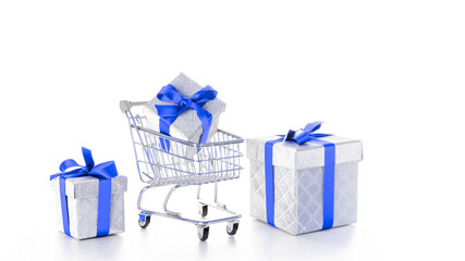 Xmas gift. Trolley cart for supermarket with christmas or birthday gift box isolated on white background. Creative idea for shopping online, xmas sale in supermarket.