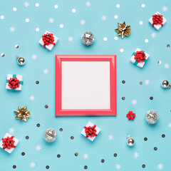 Christmas frame, gold and silver decorations, mirror disco balls, gifts on pastel blue paper background.