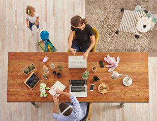 Working from home family style with baby, wooden table, laptop lamp and toy decor.