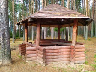 Wooden log cabin summer house gazebo in the coniferous forest