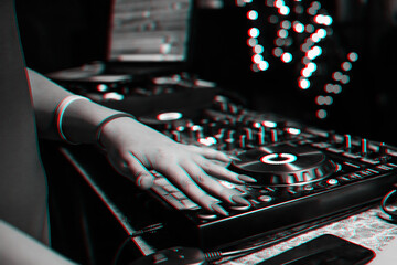 hand of a DJ girl on the background of a music controller mixer