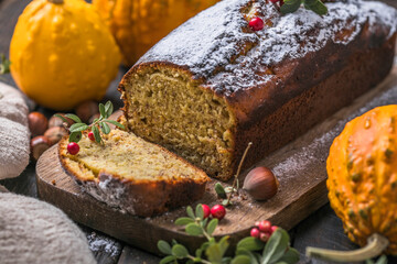 Delicious pumpkin cake on cutting board. Loaf of  bread with pumpkins.