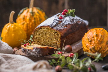 Delicious pumpkin cake on cutting board. Loaf of  bread with pumpkins.