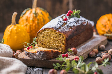 Delicious pumpkin cake on cutting board. Loaf of  bread with pumpkins.