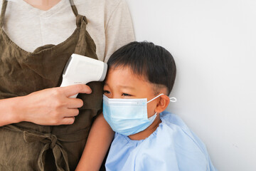 幼児の体温測定をする保育士