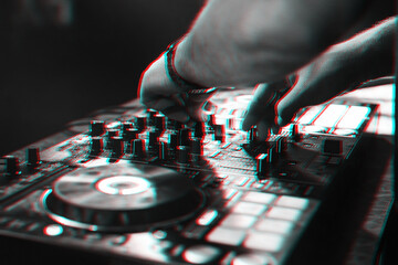 DJ plays music with his hands on a mixer controller