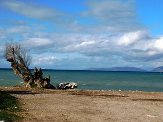 A view of the sea, clouds and the island of Salamina from a beach in Glyfada, Greece