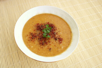 bowl of lentil soup with spice and parsley leaves