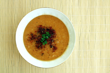 bowl of lentil soup with spice and parsley leaves