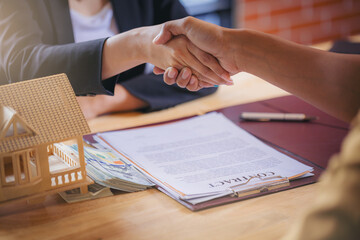 Business peoples handshake at business meeting after estate signing contract with business partners. Selected focus