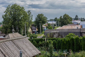Fototapeta na wymiar City street in the middle of summer. Roofs, trees, chimneys. View from the bell tower of the church. Provincial town of Borovsk in Russia.
