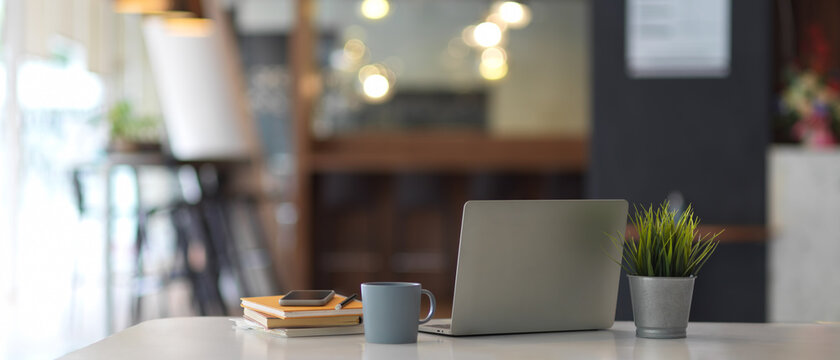 Worktable With Laptop, Supplies, Stationery And Plant Pot In Office Room