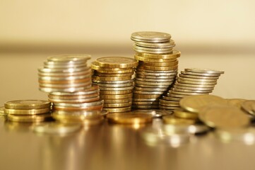 A stack of coins on a gold background.