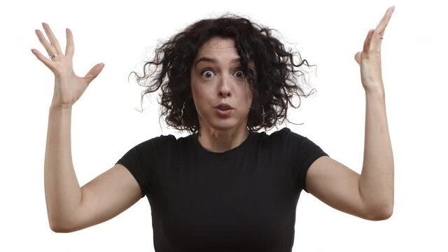 Attractive adult woman with short curly hair, wearing black t-shirt, grimacing and looking distressed, holding hands on temples and shaking head, mind exploding from stress
