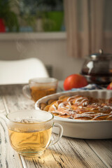 Heap of homemade apple pie close-up and copy space. A quick autumn dessert idea with tea. Autumn pie with apples, Rustic wooden background.
