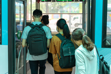 Young Asian people getting on the bus