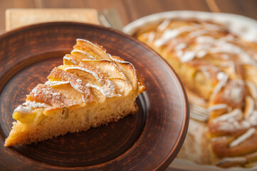 Heap of homemade apple pie close-up and copy space. A quick autumn dessert idea with tea. Autumn pie with apples, Rustic wooden background.

