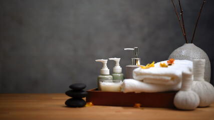 Spa table with massage stone and towels on wooden table