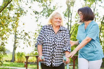 Altenpflegerin hilft Senior Frau mit Krücken