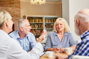 Gruppe Senioren und Therapeutin im Gespräch