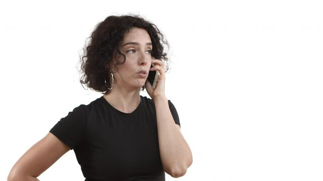 Close-up of young attractive female model with curly hair, wearing black t-shirt, having phone call and looking dissatisfied, shaking head and saying no, disagree or deny something bad