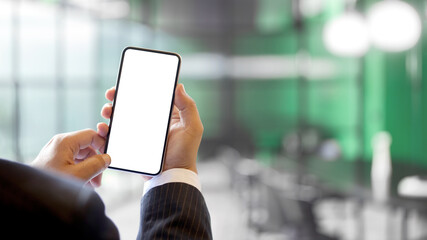 Businessman holding mock up smartphone in blurred background