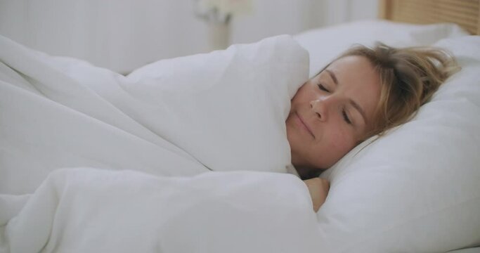 Young woman Lying in bed in the bedroom with plaid shiver freeze feeling cold at home with no central heating problem in chill season, sick ill girl wrapped in blanket having fever flu symptoms