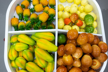 Plastic fruits on model supermarket shelf. Children pay toys