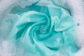 Color clothes soak in powder detergent water dissolution. Laundry concept