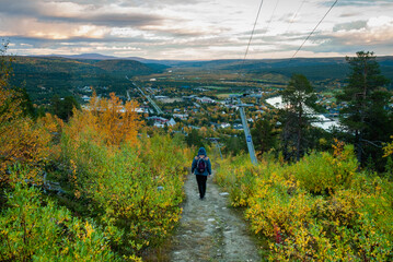 A man hiking on Oalgevarri mountain with a beautiful scenery of Karasjok village, Norway