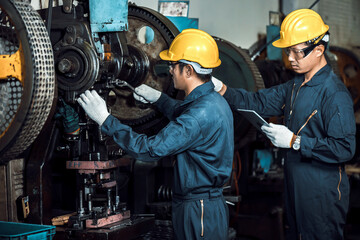 Team of Asian engineer mechanic man checking and using wrench for maintenance pressing metal machine at factory, worker at industrial working concept