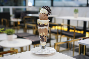 Chocolate Parfait. A tall cup of ice cream parfait, chocolate and vanilla ice cream flavour with brownie and vanilla pudding custard at cafe.