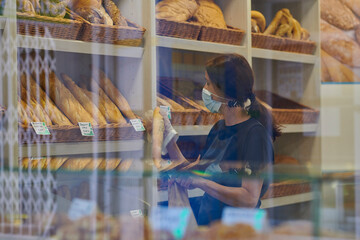 young red-haired worker working in the bakery. Small business concept. protection measures against covid 19 in small businesses