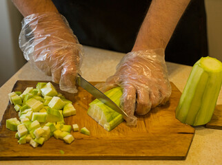 hands cut zucchini in the home kitchen