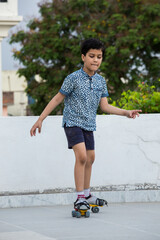 A 6 year old  Indian Boy learning and practicing roller skating on the terrace of his own house during the lock down period due to COVID 19