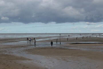 Cuxhaven, Germany: The North Sea during low tide in Cuxhaven-Salenburg. People walk on the mud...