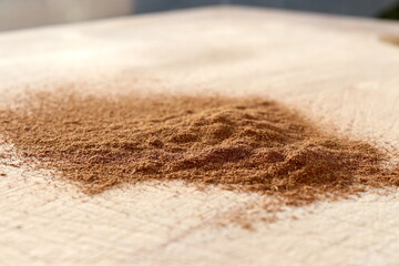 Ground Cinnamon on wooden chopping board.