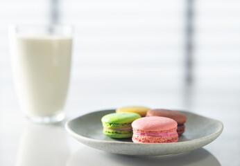 Macarons  cookies and milk on the kitchen table